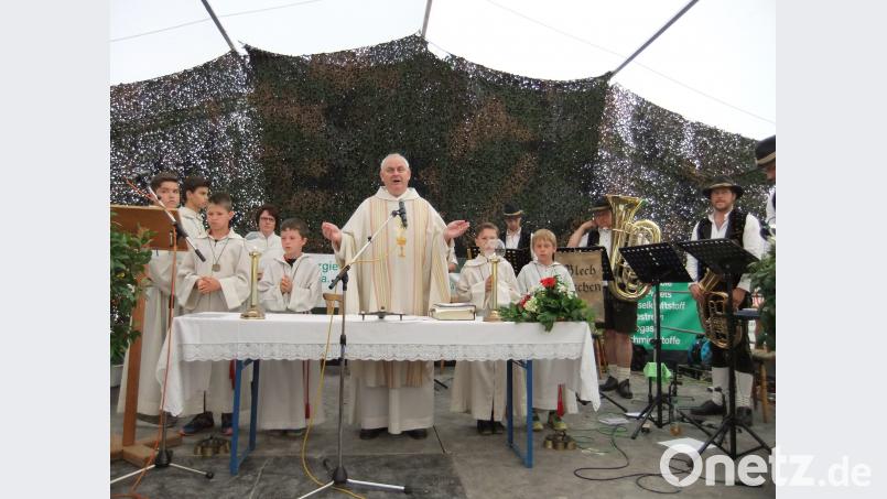 Pfarrer Herbert Grosser mit seinen Messdienern beim Gottesdienst im Festzelt. Er verweist auf den Sport, zu dem Disziplin sowie Teamgeist gehören. gm