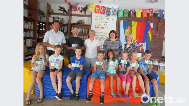 Jede Klasse der Grundschule am Rauhen Kulm schickte zwei Vertreter, um Hans Karl (hinten, Zweiter von links) die 1000-Euro-Spende zu überreichen. Dieser bedankte sich bei Rektor Franz Ficker (links) für die mittlerweile jahrelange Unterstützung der Aktion „Für das Leben und die Hoffnung“. Die Lehrerinnen Sibylle Stock, Ulrike Kneidl und Maria Neumann (hinten, von rechts) freuten sich ebenfalls über den hohen Spendenbetrag. ffz