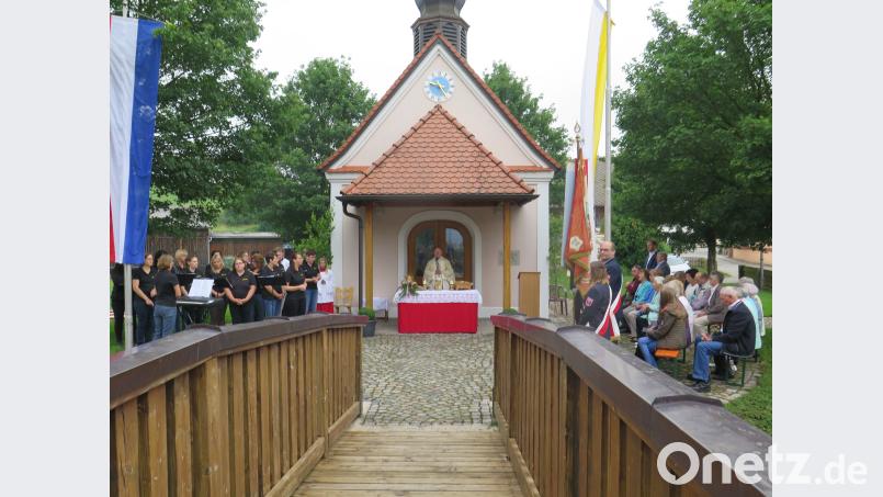 Der Chor „Laudate“ (links) gestaltet mit Liedern den Festgottesdienst, den Pfarrer Heribert Stretz (Mitte) vor der Kapelle zelebriert. jzk