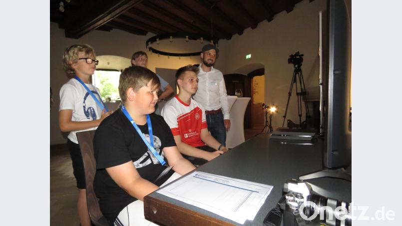 Auch T1-Leiter Philipp Reich (rechts) schaute gespannt zu, während Bundesligaspieler Tobias Hölzl  (Zweiter von rechts) aus Regensburg die Buben ins virtuelle Fußball einführte. ubb