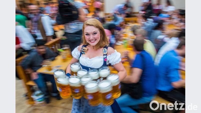 Eine Kellnerin trägt beim Münchner Oktoberfest auf der Theresienwiese zehn Maß Bier zu einem Tisch. Foto: Marc Müller/Archiv Marc Müller