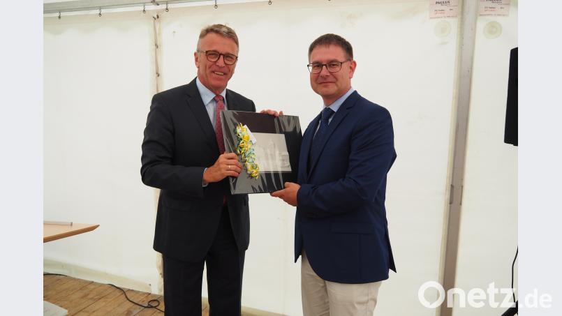 Bürgermeister Franz Stahl (links) übergibt an Geschäftsstellenleiter Thomas Franz ein Geschenk. sbü