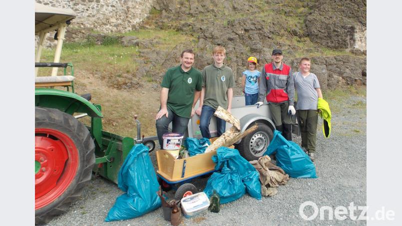 Mit dem Bollerwagen fahren die Helfer bei der Ramadama-Aktion zunächst den Müll zusammen, um ihn dann auf einen Traktoranhänger zu verladen. hl