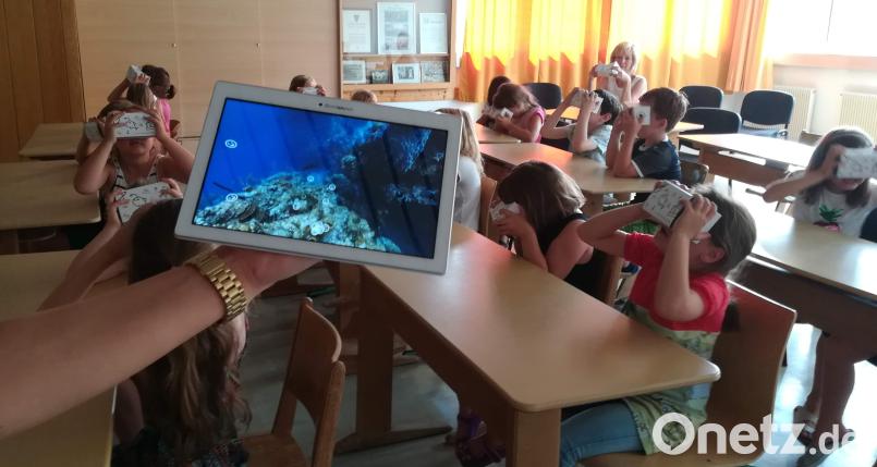 Das von Adile Karadan vorgestellte Programm Google Expeditions macht es möglich: Mit ihren Virtual-Reality-Brillen bestaunen die Mädchen und Jungen der Kombi-Klasse 1/2 und ihrer Klassenleiterin Hildegard Feyrer (hinten links) die bunte Unterwasserwelt eines Korallenriffs. u