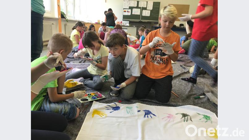Gruppenarbeit mit Utensilien aus der Sprachbox. Mit Handabdrucken lässt sich ein buntes Kunstwerk gestalten. eib