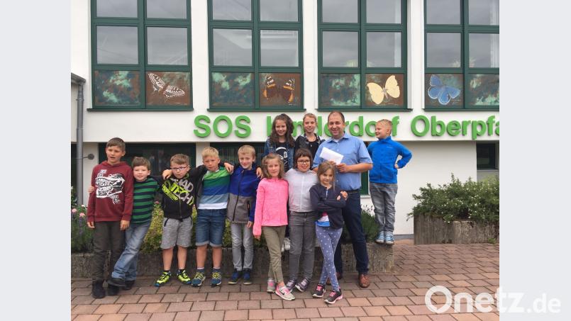 Holger Hassel (Zweiter von rechts), der Leiter des Immenreuther SOS-Kinderdorfes, freute sich über das Kuvert mit vierstelligem Inhalt, das ihm die Eschenbacher Erstkommunionkinder überreichten. do