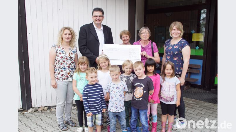 Rosa Huber (Zweite von rechts) und Marianne Kopp überreichen an Pfarrer Wolfgang Dietz den Spendenscheck. Die Kinderhausleiterin Anja Herdegen (rechts) und ihre Stellvertreterin Elisabeth Baier (links) finden damit bestimmt eine Verwendung für Spielgeräte für die Kinder. mmj