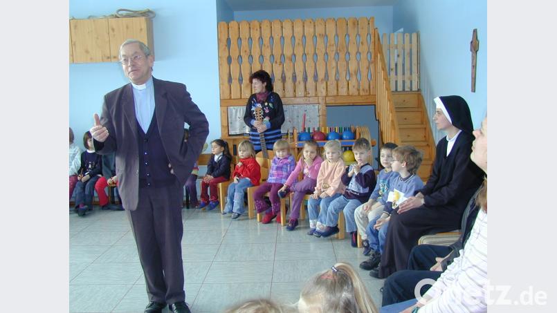 Pater Dymny zu Besuch in einem der beiden kirchlichen Kindergärten, die unter seiner rund 17-jährigen Ära saniert wurden. Bild: Christa Schleicher