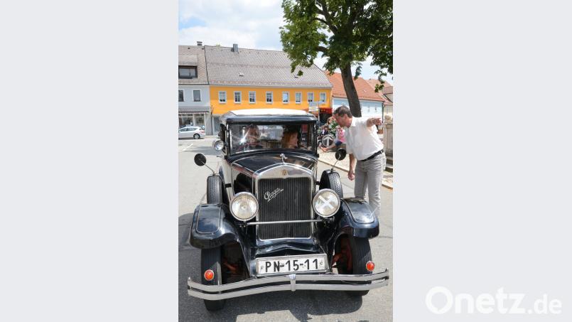„Da geht’s Richtung Parkplatz“, scheint Bürgermeister Rainer Rewitzer den Gästen aus dem Nachbarland, angereist mit einem „Praga“, Baujahr 1931, zu sagen. bey