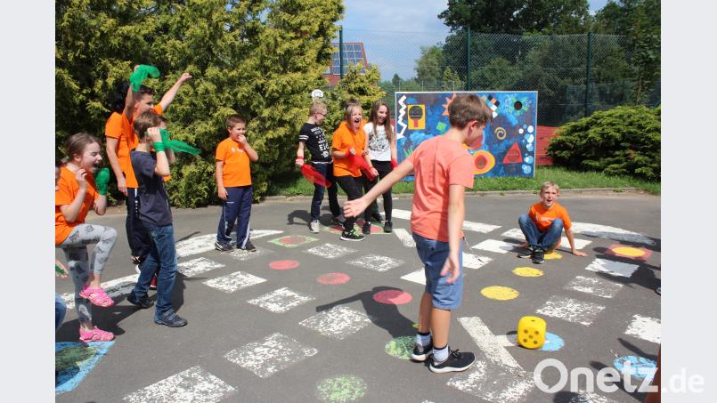 Im Pausenhof ist ein Spielbrett von &quot;Mensch ärgere dich nicht&quot; aufgemalt. Die Kinder selbst bilden die Figuren. wec