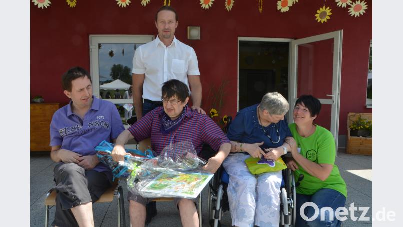 Christa Ehrendreich, Waldemar Semeniuk und Thomas Knorr (von rechts nach links) werden am Sommerfest von Heimleiter Uwe Trautner (hinten) überrascht, denn sie wurden für langjährige Bewohnerschaft geehrt. dob