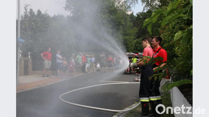 Die Kameraden der Jugendfeuerwehr, Alexander Kellner und Stefan Schmidl, zeigen eine Wasserwand  (im Hintergrund die Teilnehmer). nko