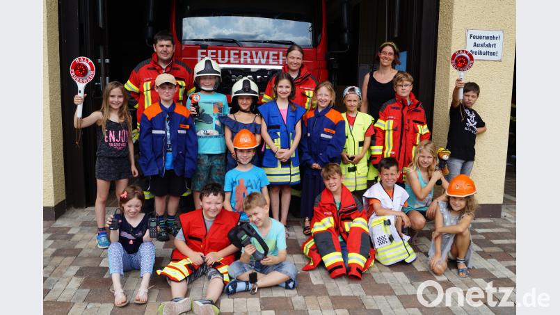 Schüler der dritten Grundschulklasse besichtigen mit ihrer Lehrerin Doris Neumann (hinten, rechts) Geräte und Einrichtungen der Feuerwehr mit Brandschutzerzieher Reinhard Eckert und stellvertretender Kommandantin Carola Adam (hinten, von links) du