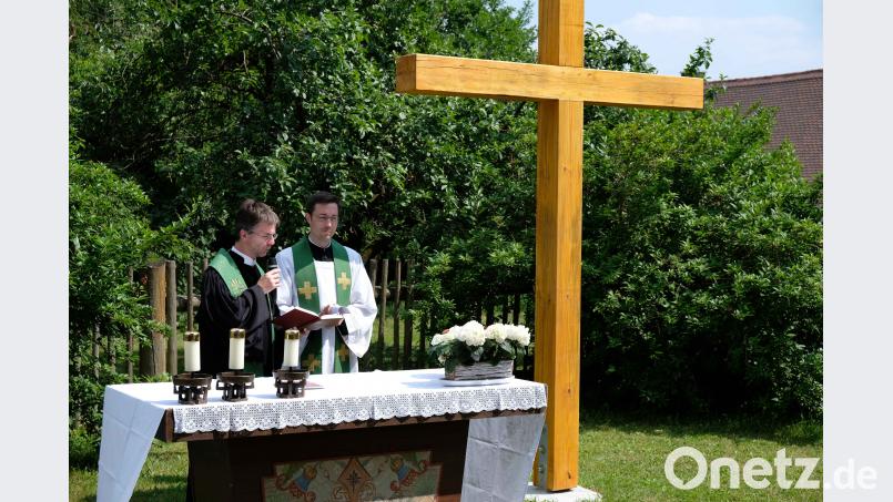 Beim gemeinsamen Kirchenfest von St. Dionysius Neunkirchen segnen der evangelische Pfarrer Andreas J. Ruhs (links) und sein katholischer Kollege Stephan Rödl das neue Holzkreuz im Pfarrgarten. Das Holz stammt aus dem gemeinsamen Kirchenwald, die Arbeit machten sich Gemeindemitglieder. exb