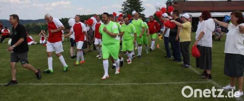 Einmarsch der beiden Mannschaften zum Endspiel des Fußballturnier, vorn dran Schiedsrichter Engelbert Horn und die späteren Sieger, NWS Löwen in roten Trikots und die Zweitplatzierten, STE Lindau in grün. Die Tanzgruppe aus Marktredwitz macht die Cheerleaders. eib