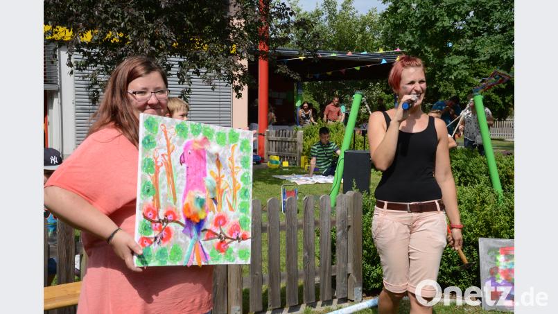 Kita-Leiterin Lena Meisel (rechts) versteigert von den Kindern gemalte Bilder zugunster der Kita-Tagesstätte. Beyerlein