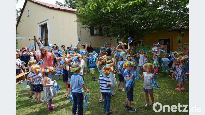 Mit den blauen Bändern in der Hand stellen die Vorschulkinder das Meer dar. Beyerlein
