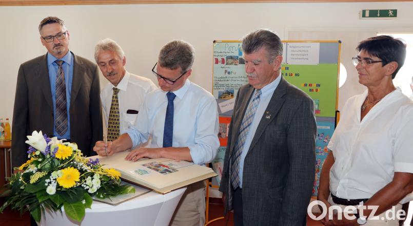 Bernd Sibler, bayerischer Staatsminister für Unterricht und Kultus, trägt sich am Donnerstag in das Goldene Buch des Marktes Schwarzenfeld ein. Götz