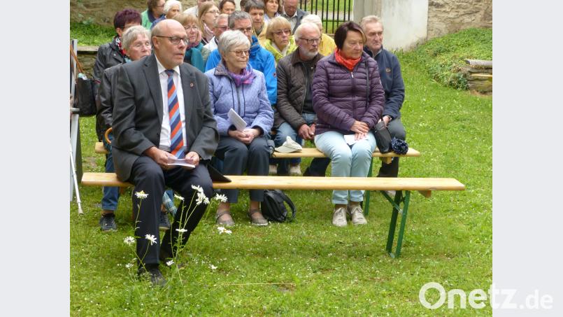 Die Gottesdienstbesucher in der „Kirche ohne Dach“ aber mit grünem Teppich und eigenem Blumenschmuck vor Altbürgermeister Albert Köstler; fsc