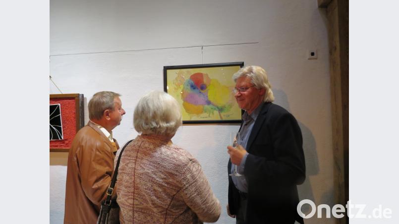 Künstler Tom Brankovic (re.), der in beiden Vereinen daheim ist, erklärt zwei Weidener Vereinsfreundinnen die Beweggründe seiner Malerei mit Titel "Kosmische Rose". ubb