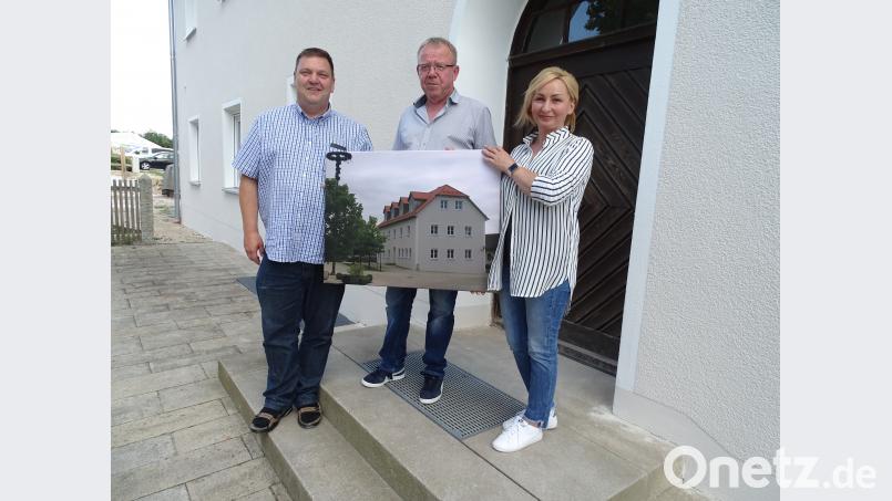 Zeit für ein Geschenk, das der Bürgermeister aus eigener Tasche
finanzierte: Christian Ziegler (links) üerreichte ein großformatiges Bild vom renovierten Dorfwirtshaus an Investor Hans Gradl und dessen Ehefrau Nadja. Bild: hou