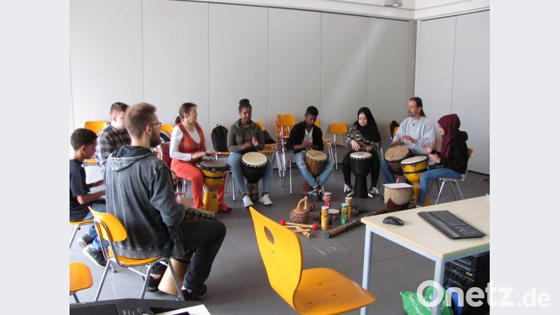 Gerd Fenzl (Zweiter von rechts) und Daniel Bayer (links)  trommeln am Montag in Weiherhammer mit Schülern mit Migrationshintergrund. sei