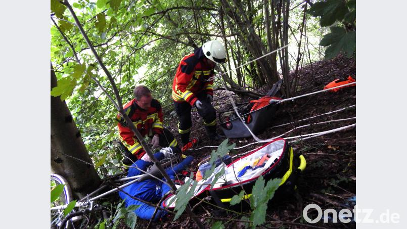 Gesichert mit Leinen versorgen die Feuerwehrler den &quot;schwerverletzten Radfahrer&quot;. Mit einer Mulde werden Rettungsgeräte über den Abhang transportiert. mde