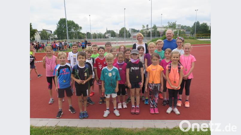 Förderlehrer Bodo Götz und Schulleiterin Christine Wiesend (hinten von rechts) gratulieren den besten Sportlern beim Grundschul-Sportfest. jzk