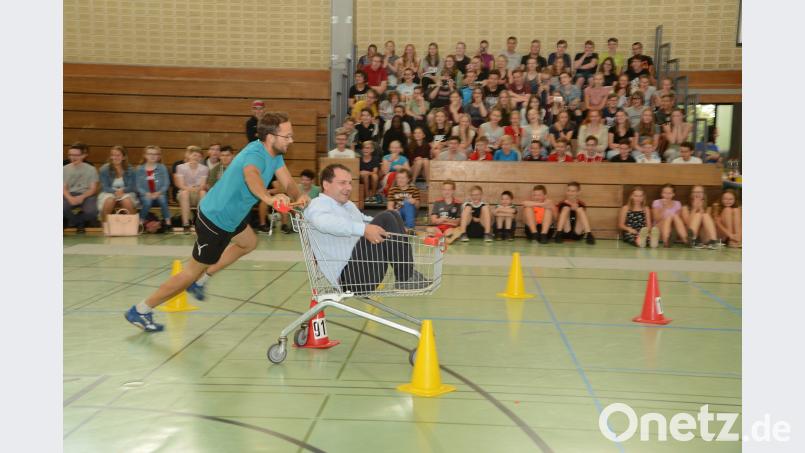 Studienrat Johannes Strauß (links) legt sich mächtig ins Zeug. Studienrat Manfred Hößl (im Einkaufswagen) hat seine helle Freude daran. Beyerlein, Walter [BEY]
