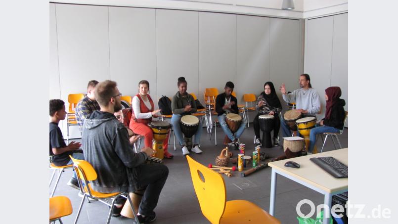 Schüler mit Migrationshintergrund lernen einen Rhythmus beim Trommeln sei