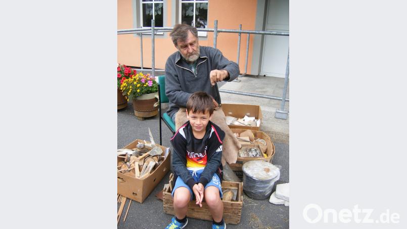 Ein  Schüler ließ sich  mit einer Klinge aus Stein die Haare schneiden. exb