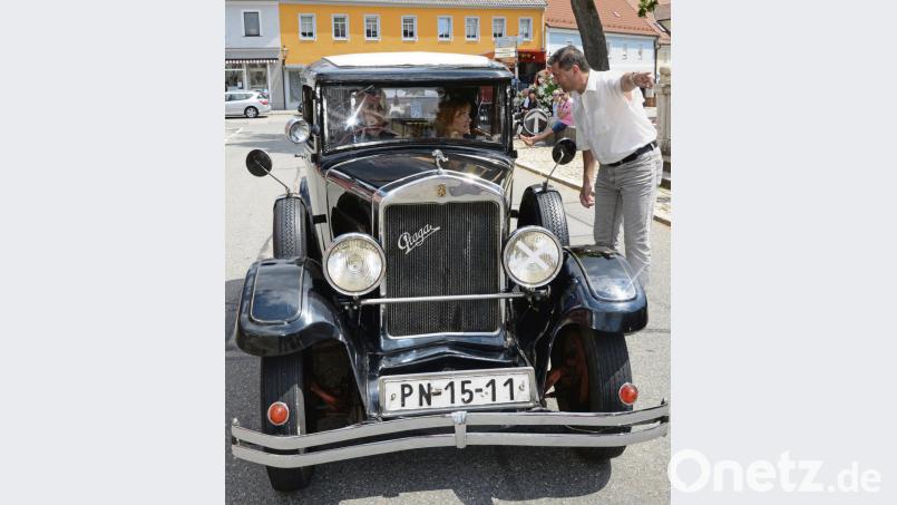 „Da geht’s Richtung Parkplatz“, scheint Bürgermeister Rainer Rewitzer den Gästen, angereist aus dem Nachbarland Tschechien in einem „Praga“, Baujahr 1931, zu sagen. bey