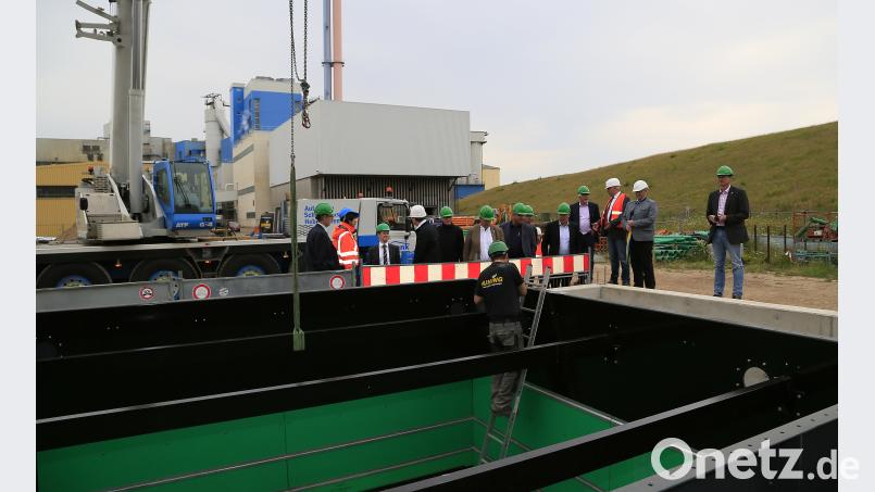 In diese Bunker wird künftig der feuchte Klärschlamm angeliefert. Sie werden noch eingehaust und bekommen Deckel, um die mögliche Geruchsbelästigung zu minimieren.  Technischer Leiter Konrad Rieger (Dritter von rechts) führte interessierte Verbandsräte durch die Baustelle. Hösamer