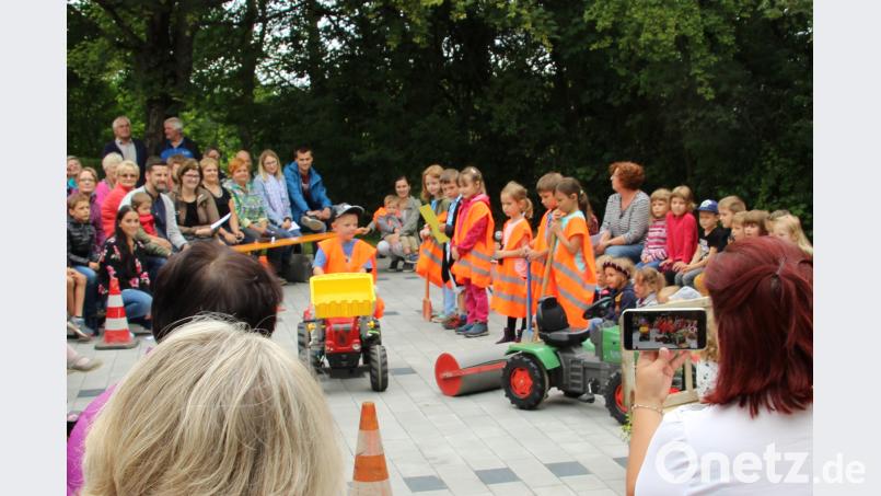 Die Kinder zeigen in einem Spiel, mit welchen Arbeitsgeräten der Parkplatz gebaut wird. ds