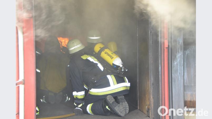 Die Feuerwehrleute erleben im Brandcontainer des Landesfeuerwehrverbands wie sich ein Feuer blitzschnell entwickelt. Die Atemschutztrupps kauern am Boden und verfolgen das Szenario. Gleich rollt die Feuerwalze über ihre Köpfe hinweg. dob