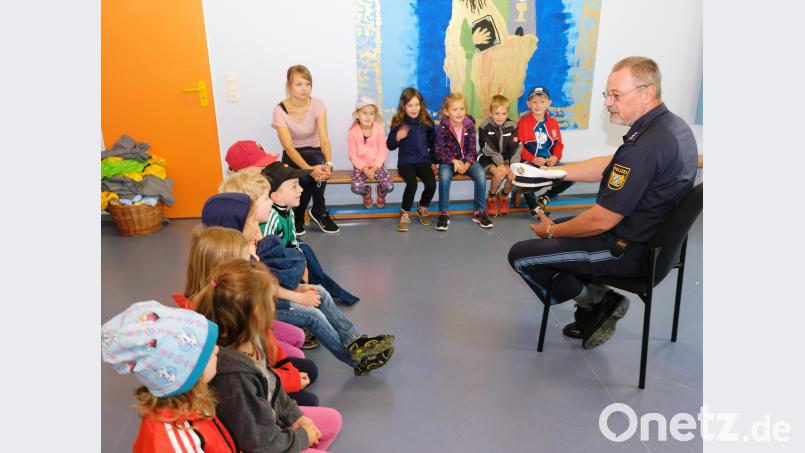 Verkehrserziehung ist ein wichtiger Bestandteil der Schulwegsicherheit. Vor der Praxis auf öffentlichen Straßen und Gehwegen kommt in der Kindertagesstätte Speinshart für die Vorschulkinder und Erzieherin Annalena Herr eine „Trockenübung“ mit Verkehrserzieher Christian Simon (rechts) von der Polizeiinspektion Eschenbach. do