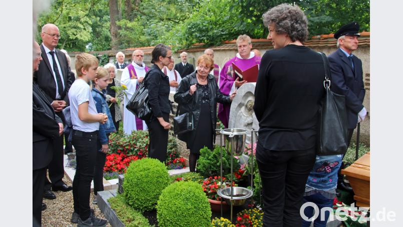 Gelassene Trauer: Die lächelnde Bärbel Panzer (Mitte) macht am Grab ihres Mannes Kindern und Enkeln Mut. Bild: Herda
