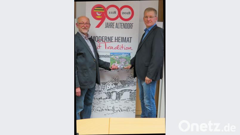 Hans Baumer (rechts) übergibt das erste druckfrische Exemplar seines Fotobuches an Bürgermeister Georg Köppl. Bild: kö