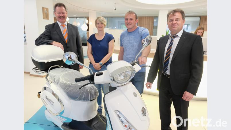 Bei der Sonderverlosung des VR-Gewinnsparvereins entfiel auf den Kunden Johann Bauer (Mitte mit Gattin Doris) der Raiffeisenbank im Naabtal als Hauptpreis ein Elektroroller. Vorstands Bernhard Werner (links) und Kundenberater Hans Braun (rechts) übergaben Schlüssel und Papiere. Bild: ohr