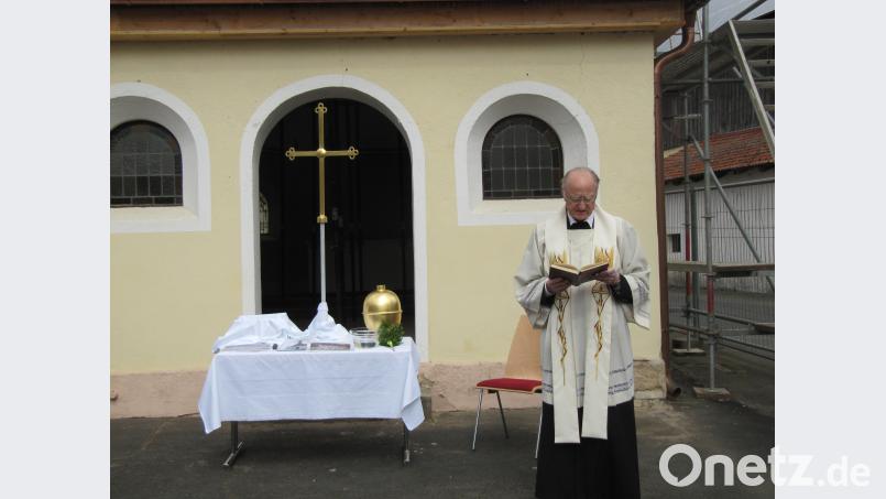 Pfarrer Eduard Feichtmeier weiht das renovierte Kreuz und die goldene Kugel fg