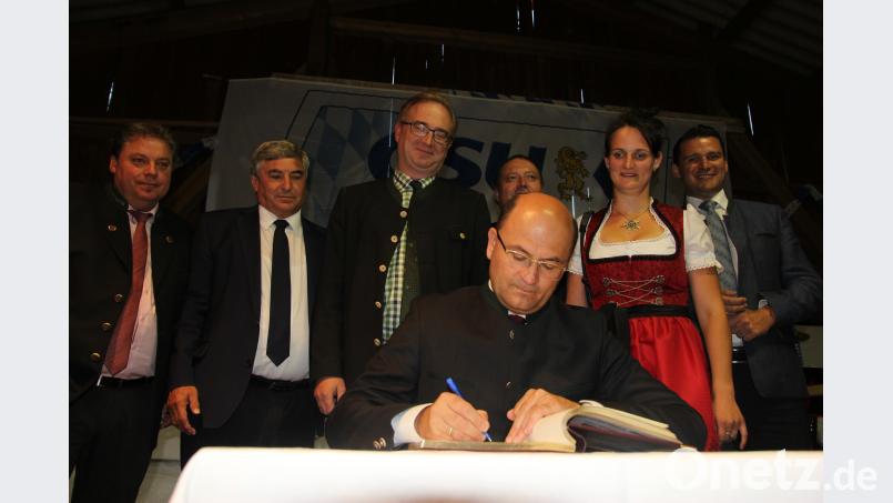 Finanzminister Füracker trägt sich in das Goldene Buch der Gemeinde Schwarzach ein. Altmann