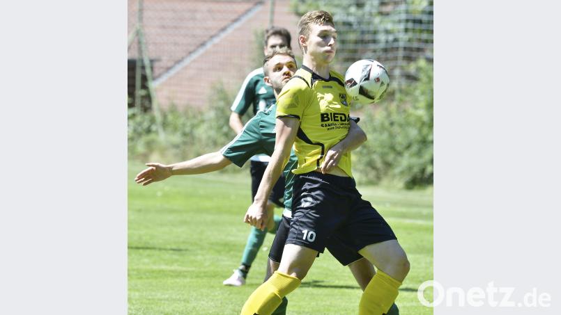 Der Haselmühler Spieler klammert Stürmer Martin Popp vom FC Amberg (vorne) bei der Ballannahme. Ziegler