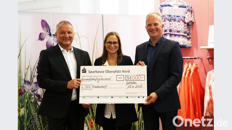 Vertriebsleiter Markus Enders (links) und Thomas Guttenberger (rechts), Leiter Kundenbetreuung der Witt-Gruppe, überreichen den  Scheck an Tanja Korn von SOS-Kinderdorf. exb