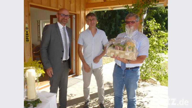 Bürgermeister Maximilian Beer und der örtliche Beauftragte Günter Auburger (von links) bedankten sich mit einem Geschenkkorb bei Baudirektor Werner Bachseitz. mad