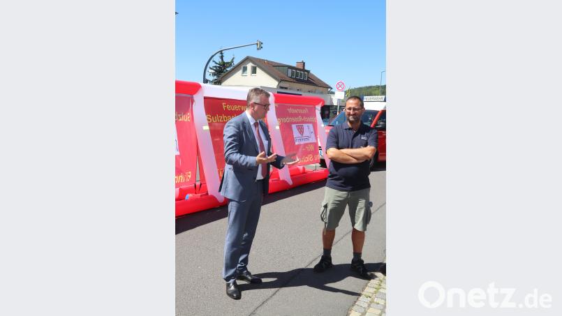 Kommandant Armin Buchwald (rechts) stellte zusammen mit Bürgermeister Michael Göth den Besuchern die neue Sichtschutzwand vor, die künftig Schaulustige abhalten soll, Rettungskräfte zu behindern. Bild: Franitza
