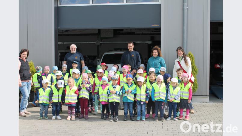 Die Kindergartenkinder in der Autowerkstatt, wo sie mit  Sicherheitswarnwesten ausgestattet wurden. exb