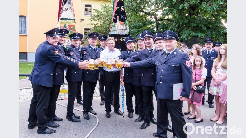 Die Funktionäre der beiden Wehren stoßen zusammen mit Schirmherrn Norbert Eckl auf die Patenschaft an. Die Freude darüber und die Vorfreude auf das Fest waren auch beim anschließenden Umtrunk im Feuerwehrhaus sichtbar. tkr