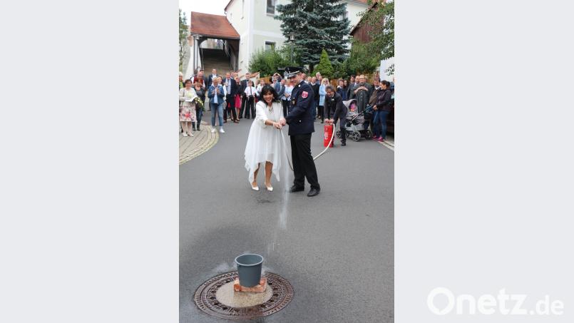 Das Brautpaar muss eine erste Bewährungsprobe bestehen. Der Bräutigam pumpt das Wasser in den Schlauch, und die Braut muss zielen. Doch der Eimer will einfach nicht fallen. rpp