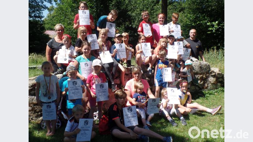 Mit Freude und voller Stolz über ihr erfolgreiches Abschneiden beim Leichtathletiksportfest zeigen die jungen Buben und Mädchen ihre Urkunden und Medaillen. (Ganz rechts), TuS-Vorsitzender Klaus Filbinger und (links hinten) TuS-Übungsleiterin Marion Jendrusch. br