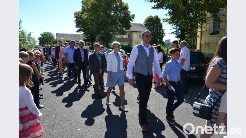 Paten und Firmkinder im Festzug zur St. Georg Kirche. plym